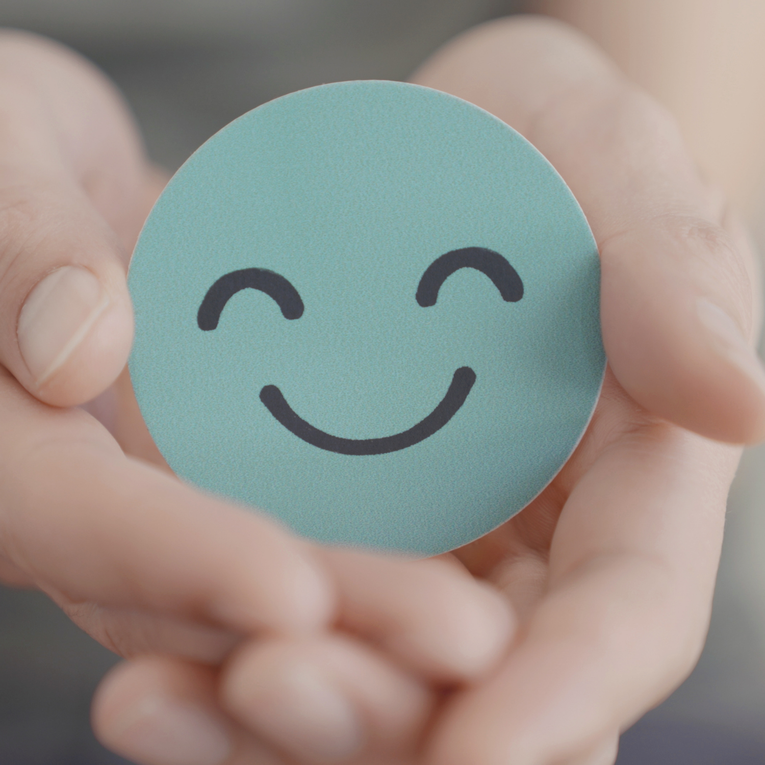 Mental Coaching Ulm – Positive Veränderung Hand hält Smiley als Symbol für mentale Stärke und positive Veränderung durch Mental Coaching bei Tatendrang Training in Ulm